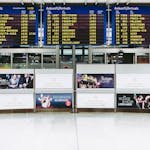 Electronic displays showing flight arrivals at Nuremberg Airport terminal.