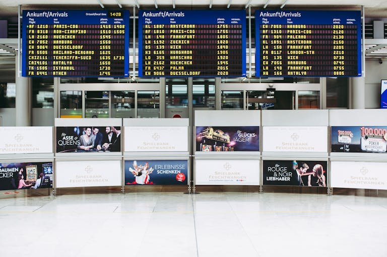 Electronic displays showing flight arrivals at Nuremberg Airport terminal.