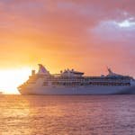 A majestic cruise ship sails at sunset off the coast of Grenada, showcasing luxury travel. Cruise vs Resort