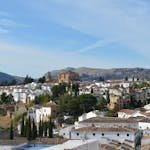 A picturesque view of Ronda, Spain, showcasing historic architecture against a mountain backdrop.
