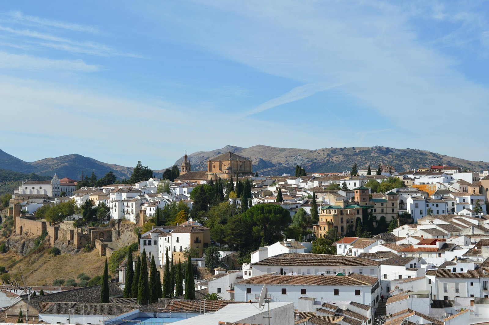 A picturesque view of Ronda, Spain, showcasing historic architecture against a mountain backdrop.