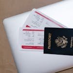 Close-up of a passport and boarding passes on a laptop, symbolizing travel preparation. Travel Documents