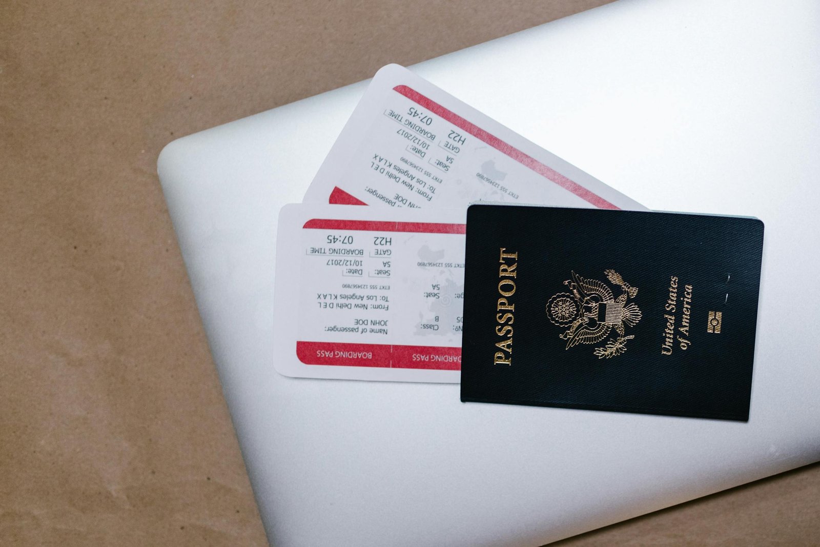 Close-up of a passport and boarding passes on a laptop, symbolizing travel preparation. Travel Documents