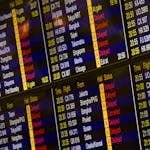 Close-up of digital flight information board showing arrivals and departures at an airport.