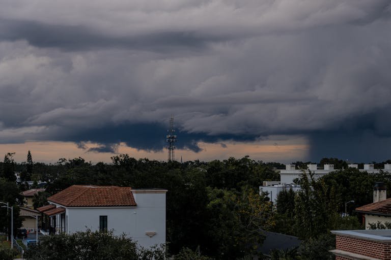 Stormy clouds loom over a cityscape, highlighting a dramatic sky and weather phenomena.