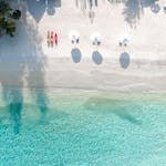 Stunning aerial view of a tropical beach with white sand and turquoise waters, perfect for a seaside escape.