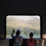 Two children gaze outside a train window, enjoying a journey through the Belarusian countryside. - kids travel