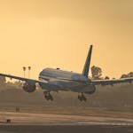 United Airlines aircraft landing at Los Angeles airport runway during a vibrant sunset.