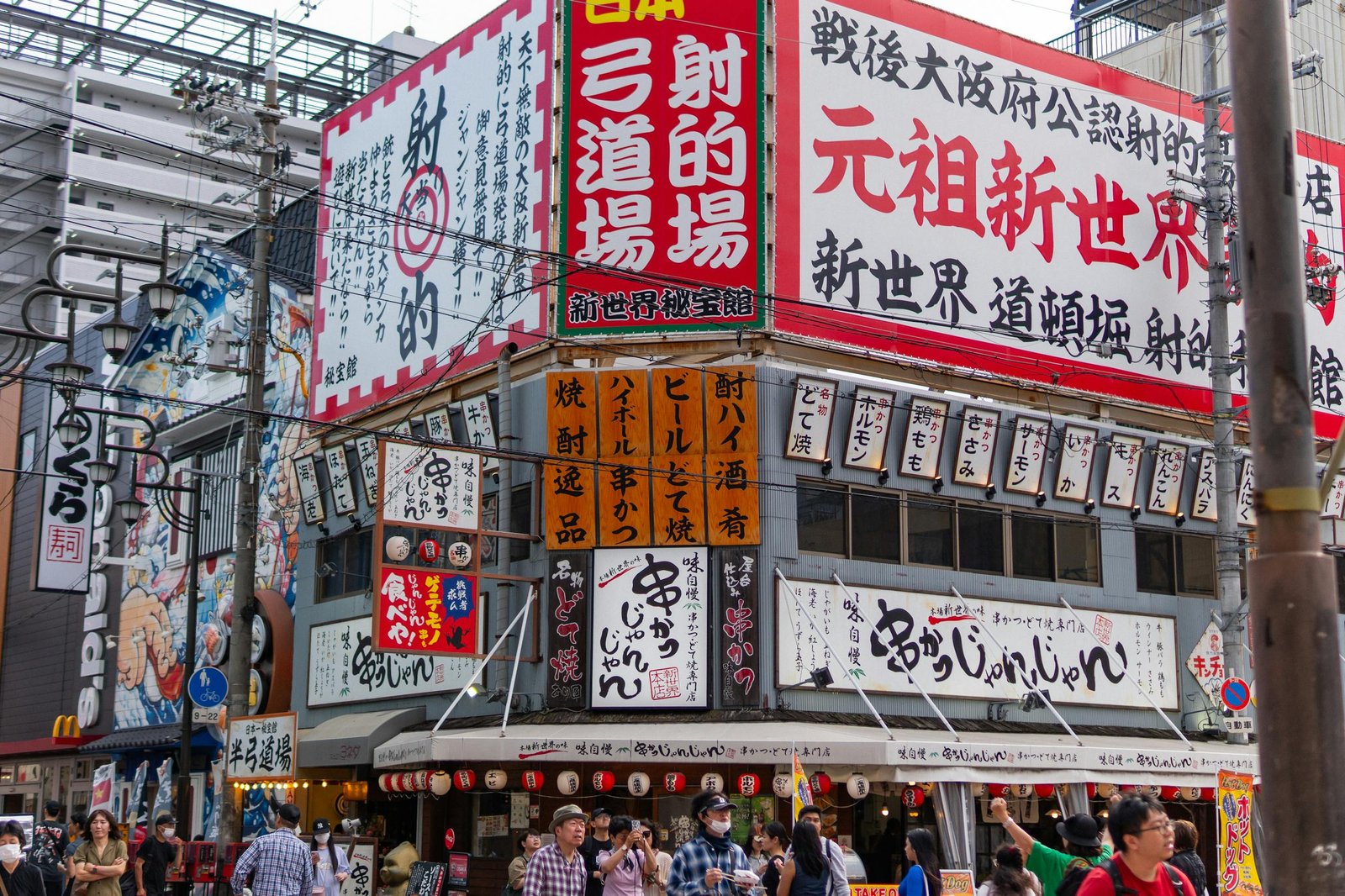 Bustling Osaka street scene with colorful signage, people, and urban architecture. A lively glimpse of Japanese city life.