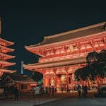 Illuminated Senso-ji Temple in Tokyo at night, showcasing traditional Japanese architecture.