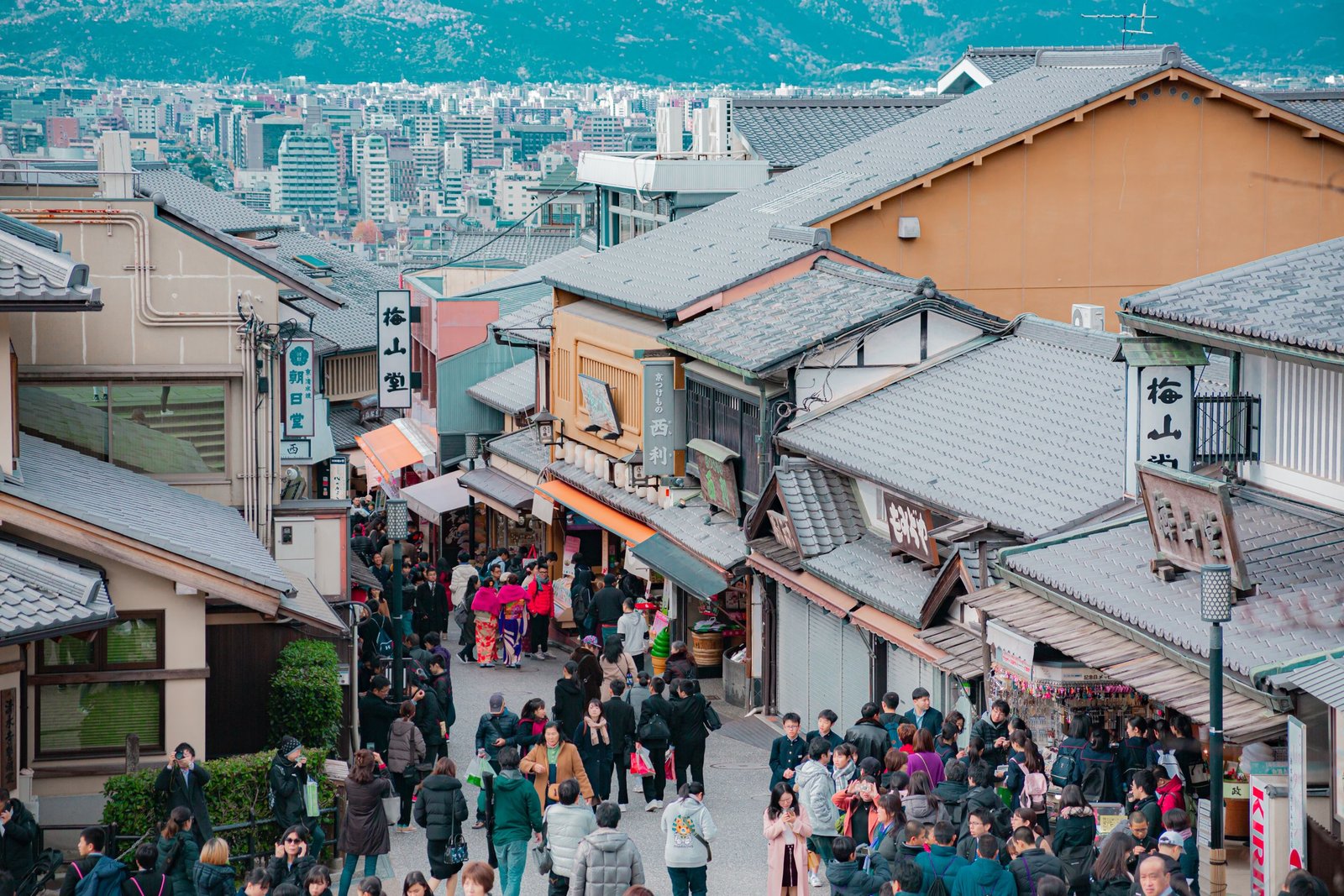 First Trip to Japan: Plan Ahead! 1 Crowds walk through a vibrant street in a historic Japanese town, full of traditional architecture.